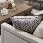 Bold patterned accent pillows in a monochromatic living room